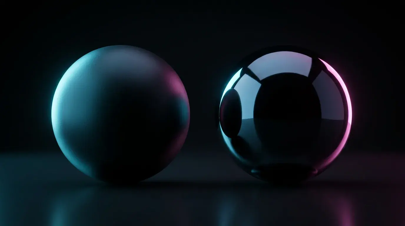 Two dark spheres side by side on a reflective surface, the left one matte and the right one mirror-polished